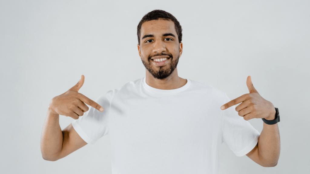 man pointing at his plain white shirt