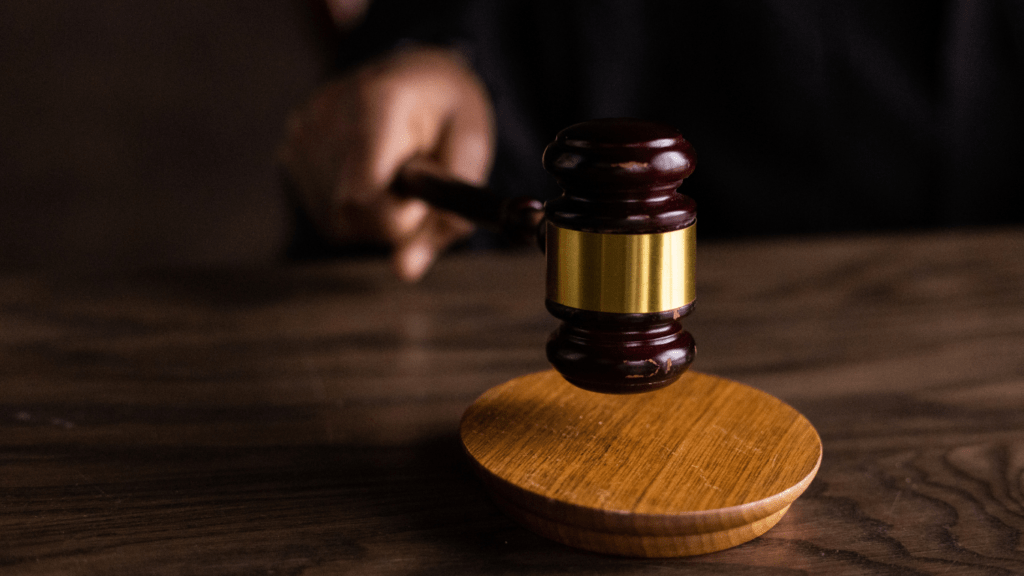 a person in a suit is holding a gavel in front of a desk