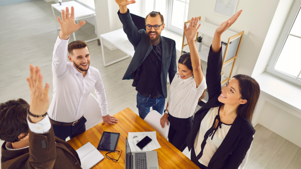 a group of business people raising their hands in the air