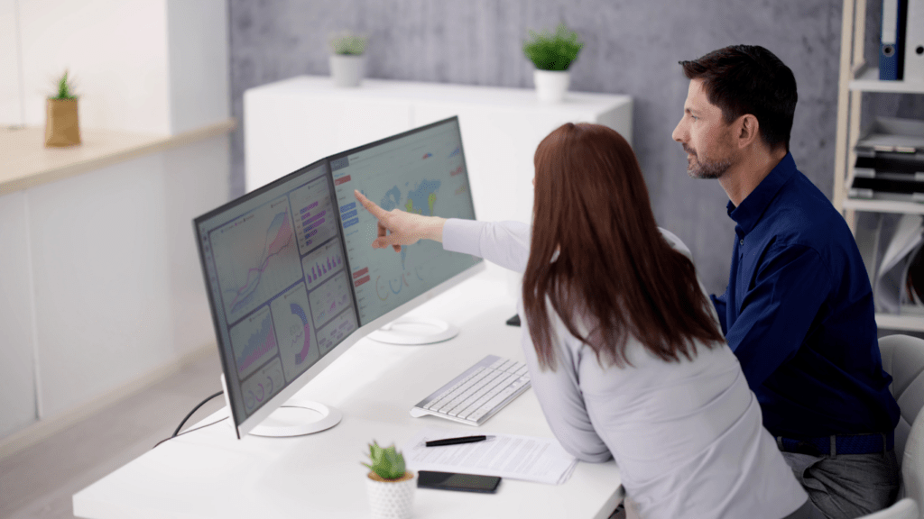 Two people pointing at a computer screen