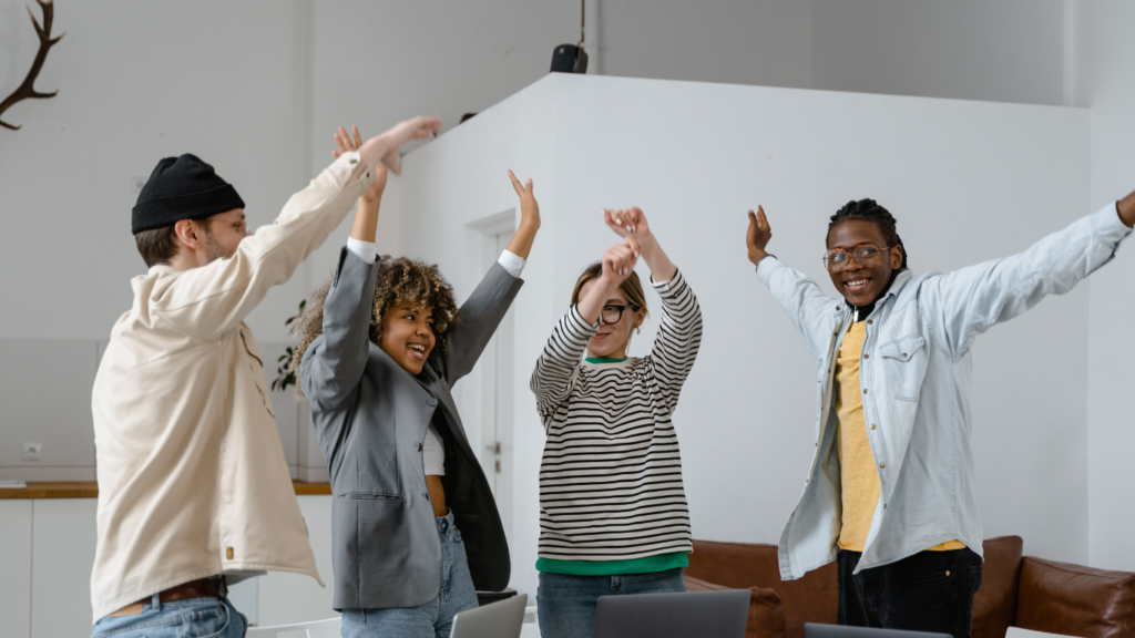 a group of business people raising their hands in the air